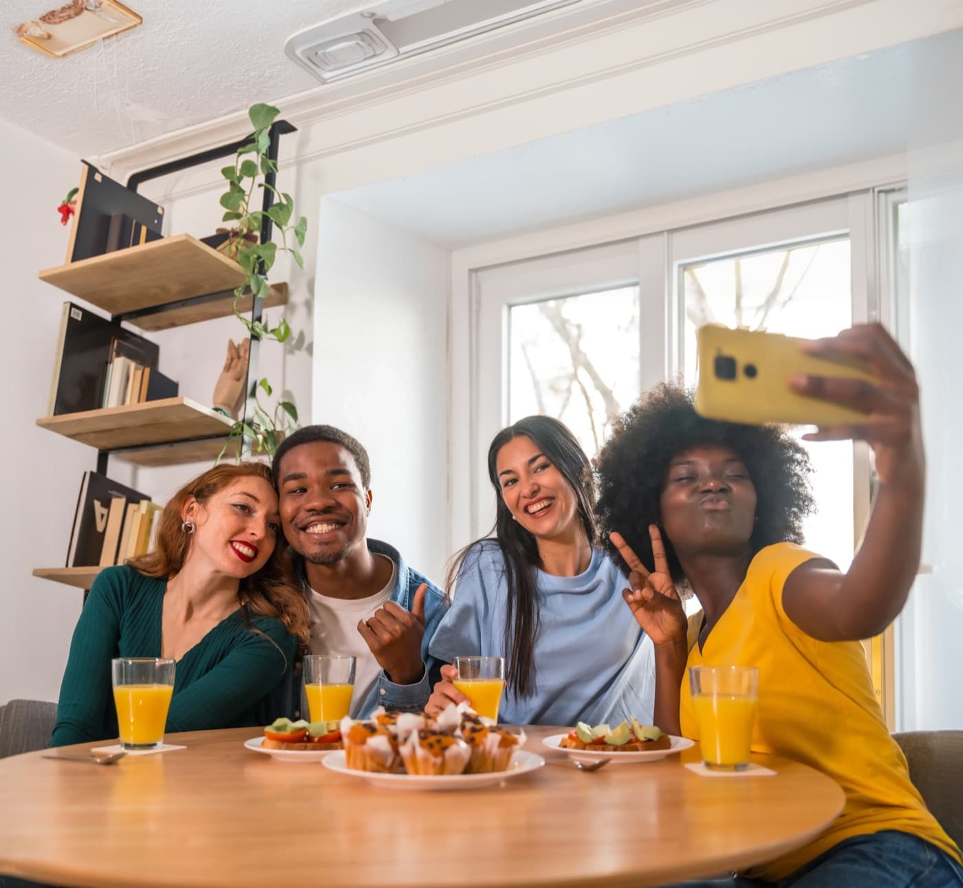 Grupo de amigos reunido tirando uma selfie durante uma refeição