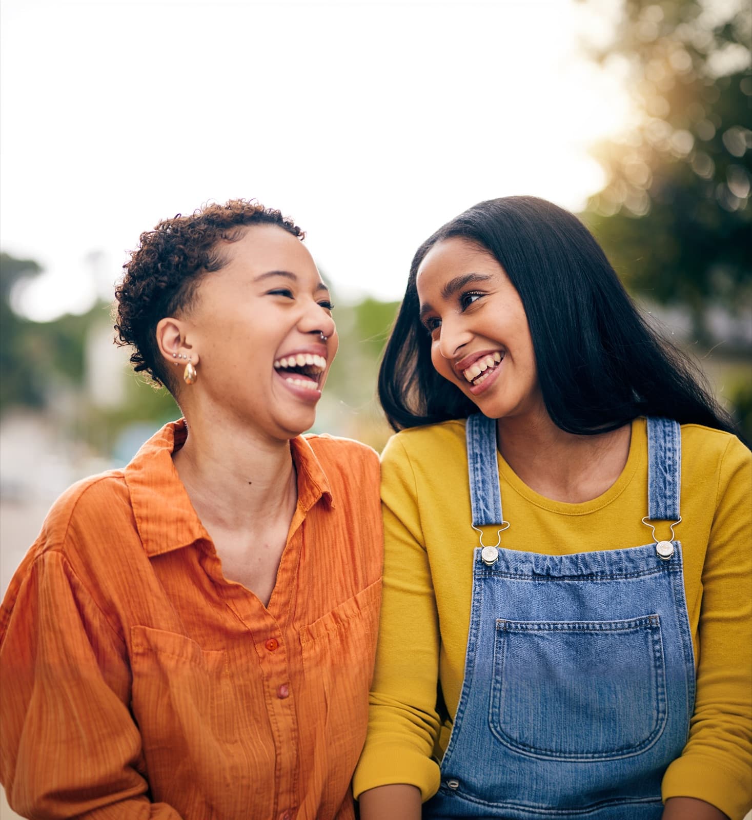 Duas mulheres sorrindo juntas ao ar livre